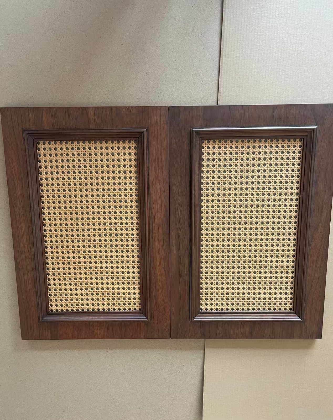 Paired black walnut cabinet doors with rectangular woven cane inserts.