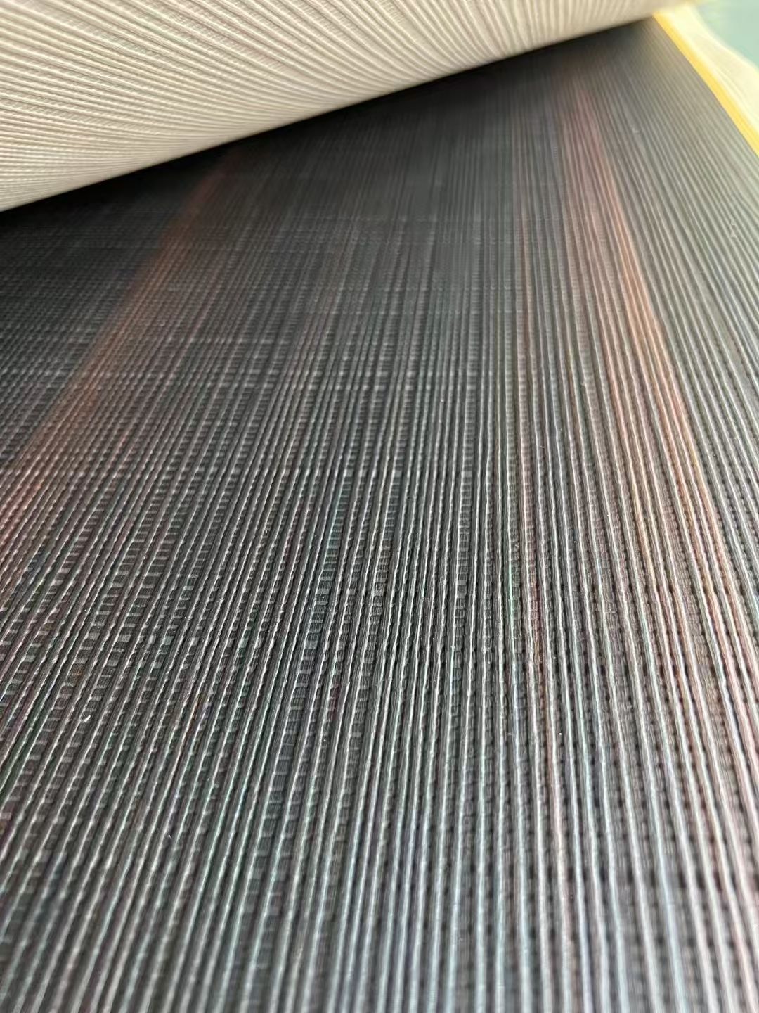 深色涂装木板上的连续线性雕刻肌理。