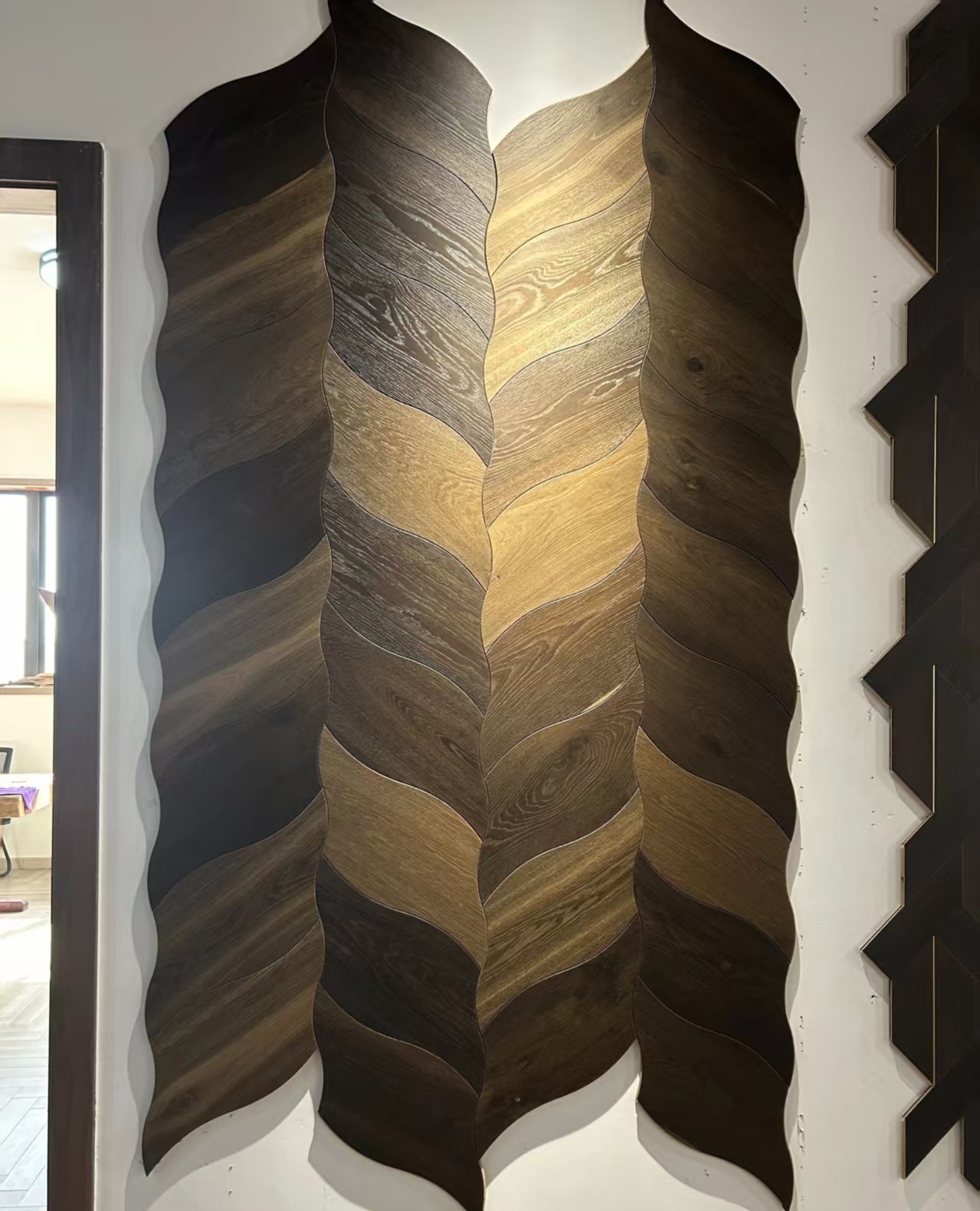 Vertical display of leaf-shaped wood pieces with contrasting natural grain