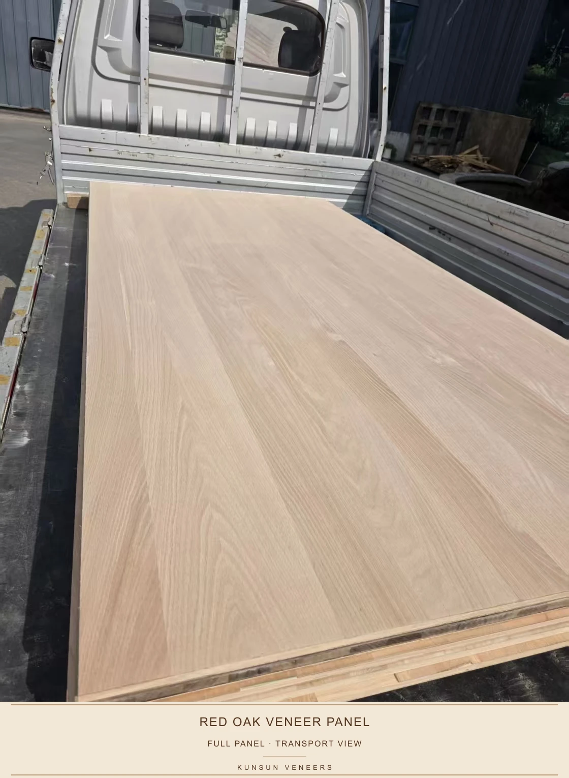 Red oak veneered panel photographed during transport, showing the full surface and panel edges.
